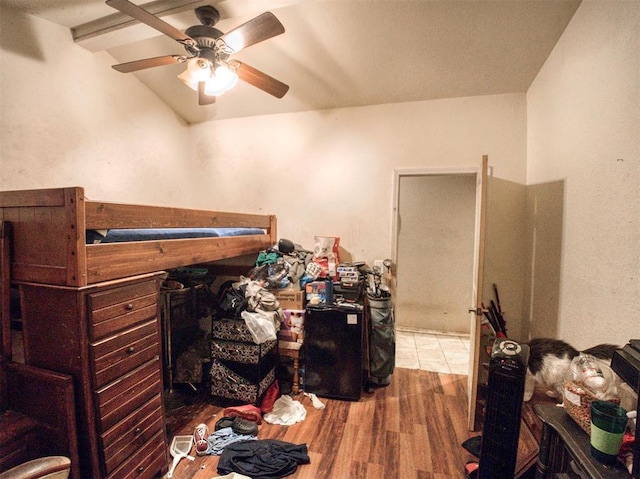 bedroom with vaulted ceiling with beams, ceiling fan, and wood-type flooring