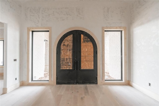 foyer with light hardwood / wood-style flooring and french doors