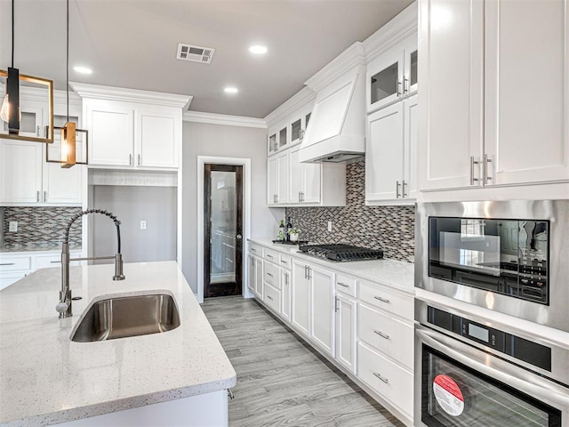 kitchen featuring white cabinets, sink, hanging light fixtures, and appliances with stainless steel finishes