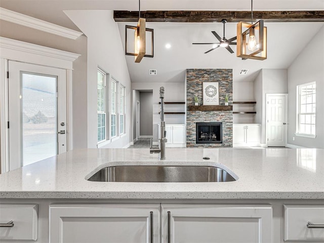 kitchen featuring white cabinetry, lofted ceiling, and decorative light fixtures