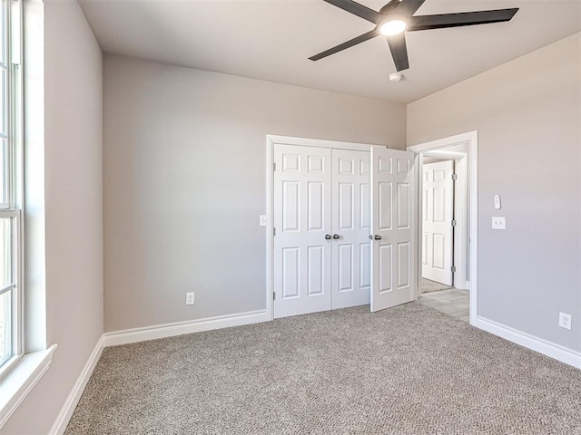 unfurnished bedroom with light carpet, a closet, and ceiling fan