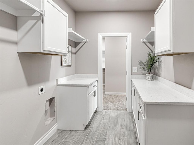 laundry room with electric dryer hookup and cabinets