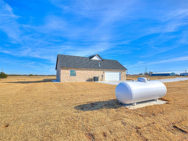 view of side of home featuring a yard and central AC unit