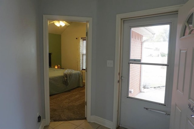 entryway featuring lofted ceiling, light tile patterned floors, and a wealth of natural light