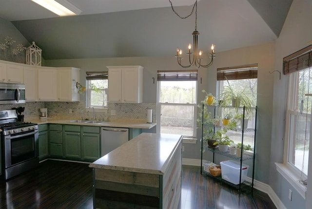 kitchen with stainless steel appliances, dark wood-type flooring, sink, green cabinetry, and lofted ceiling