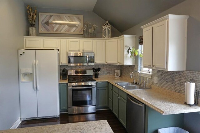 kitchen featuring lofted ceiling, white cabinetry, sink, and appliances with stainless steel finishes