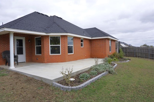 back of property with a patio area and a yard