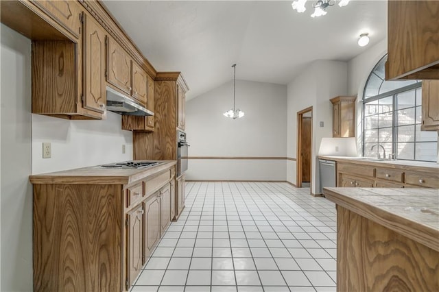 kitchen featuring a notable chandelier, pendant lighting, lofted ceiling, light tile patterned floors, and appliances with stainless steel finishes