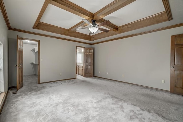 unfurnished bedroom featuring a walk in closet, ceiling fan, coffered ceiling, and ornamental molding