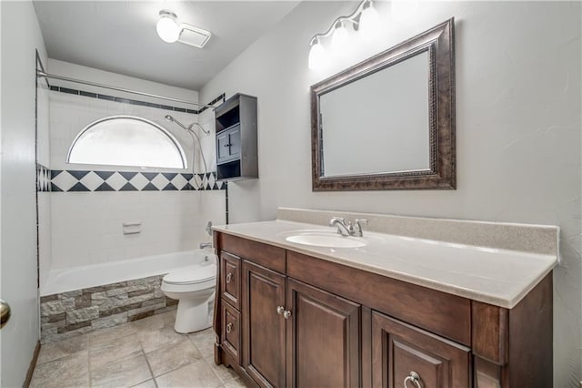 full bathroom featuring vanity, toilet, and tiled shower / bath combo