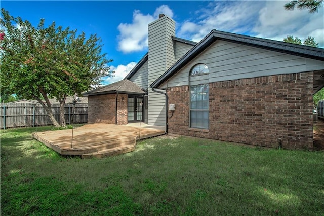 back of house with a deck, a yard, and french doors