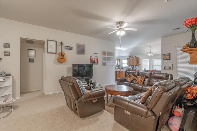 carpeted living room featuring ceiling fan with notable chandelier