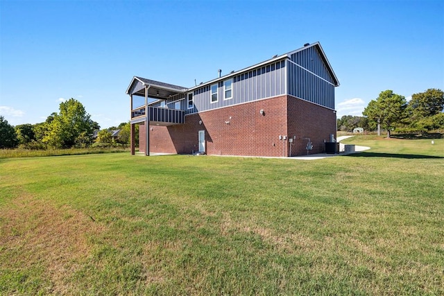 back of property with a lawn, cooling unit, and a balcony