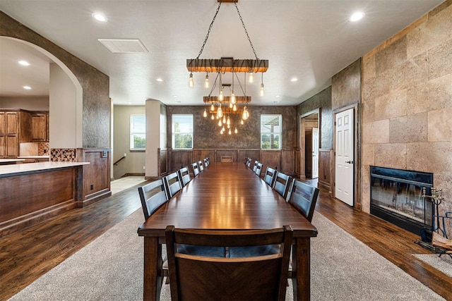 dining space with a chandelier, a fireplace, and dark wood-type flooring