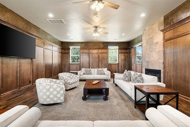 living room with dark hardwood / wood-style floors, a wealth of natural light, and a tiled fireplace