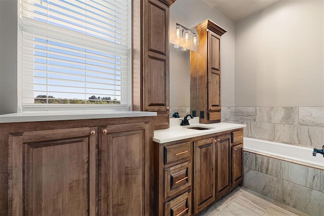 bathroom with tiled tub and vanity