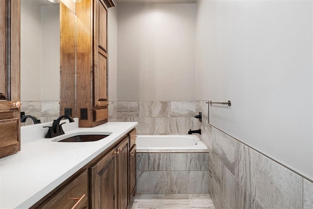 bathroom featuring vanity and tiled tub