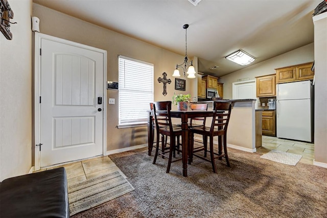 dining area featuring an inviting chandelier, vaulted ceiling, and light colored carpet