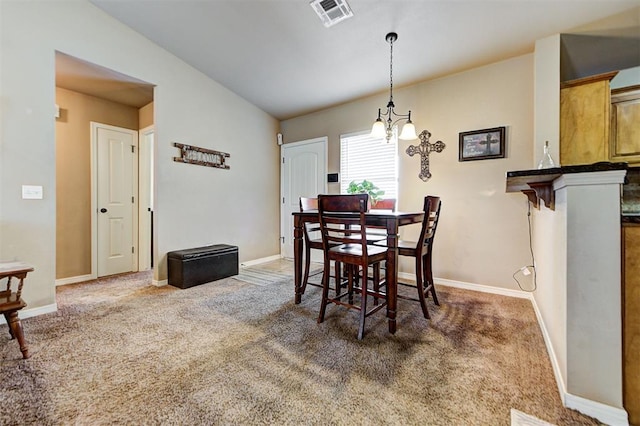 dining room featuring vaulted ceiling, an inviting chandelier, and dark carpet