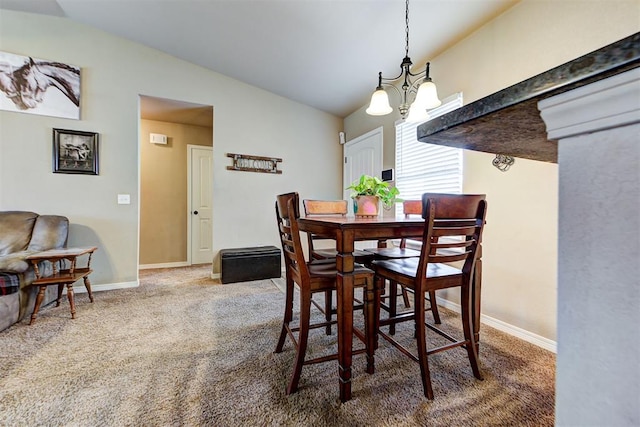 dining space with carpet flooring, lofted ceiling, and an inviting chandelier