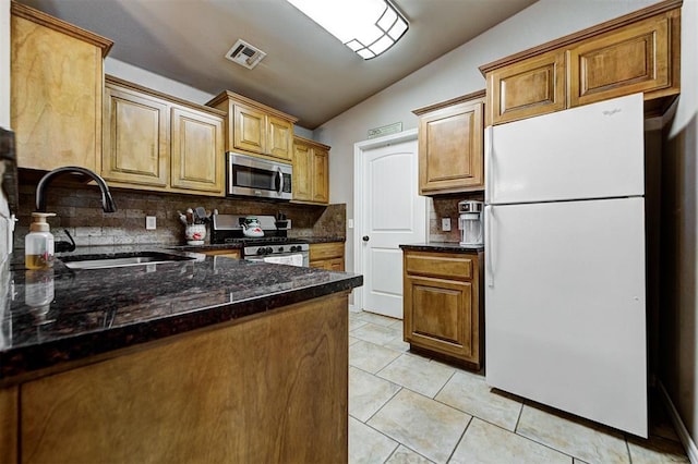 kitchen with decorative backsplash, appliances with stainless steel finishes, vaulted ceiling, and sink