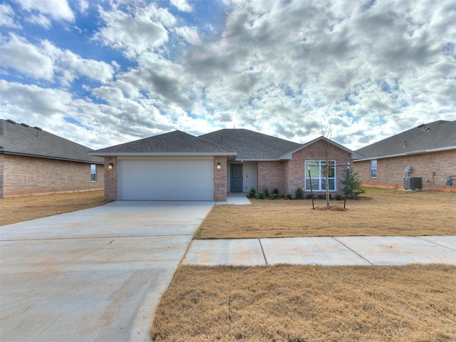 view of front of house featuring a front yard, central AC, and a garage