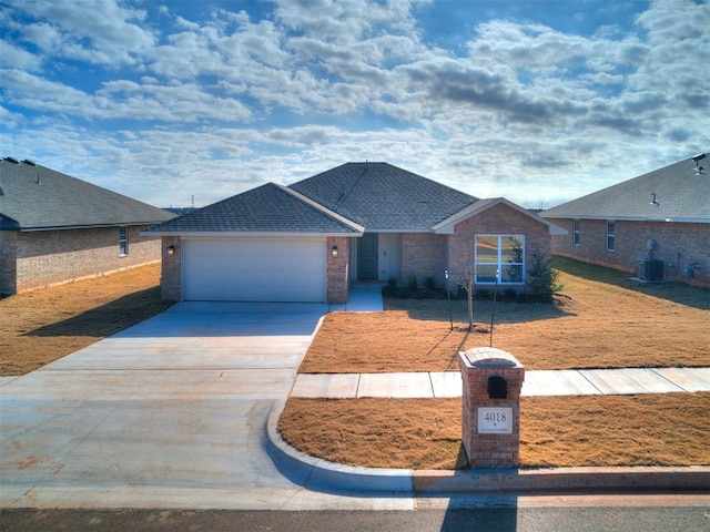 view of front facade with central AC unit, a garage, and a front yard