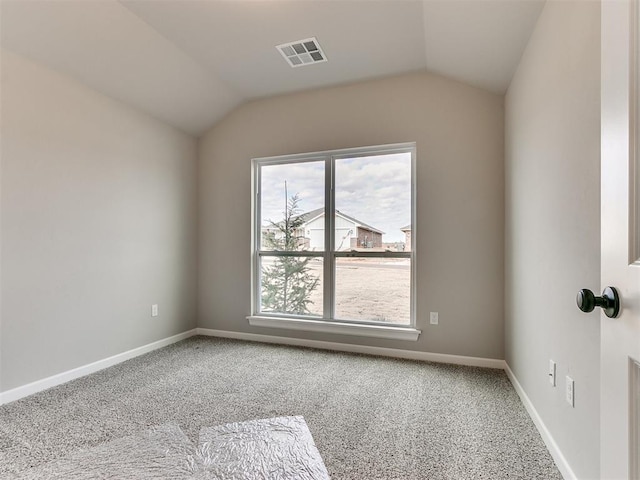 carpeted empty room featuring vaulted ceiling