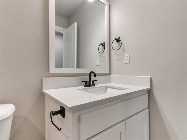 bathroom featuring vanity and toilet