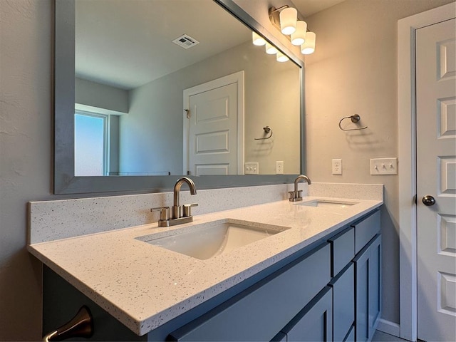 bathroom with a sink, visible vents, and double vanity