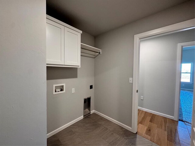 clothes washing area featuring washer hookup, cabinet space, baseboards, and electric dryer hookup