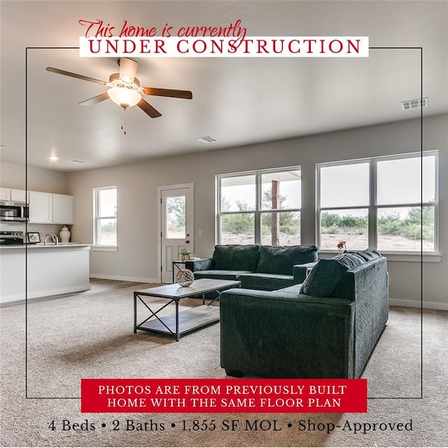 living room with light carpet, visible vents, and baseboards