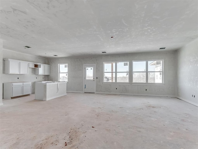 unfurnished living room with visible vents