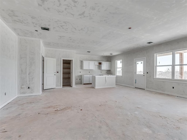 unfurnished living room featuring visible vents and concrete flooring