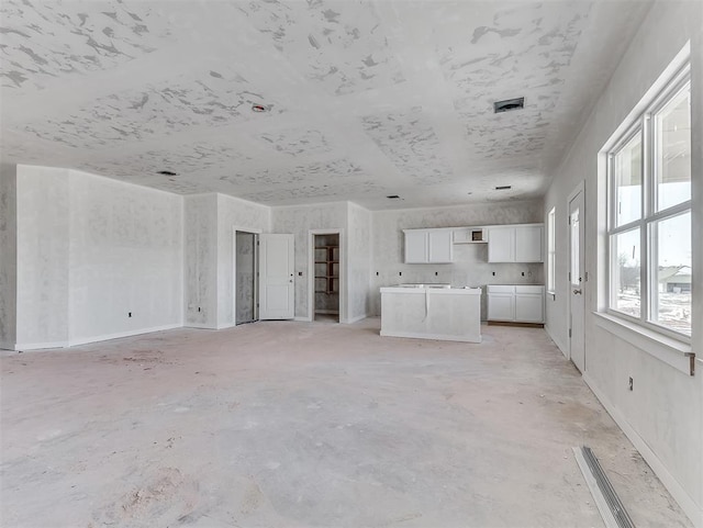 unfurnished living room featuring visible vents and concrete flooring