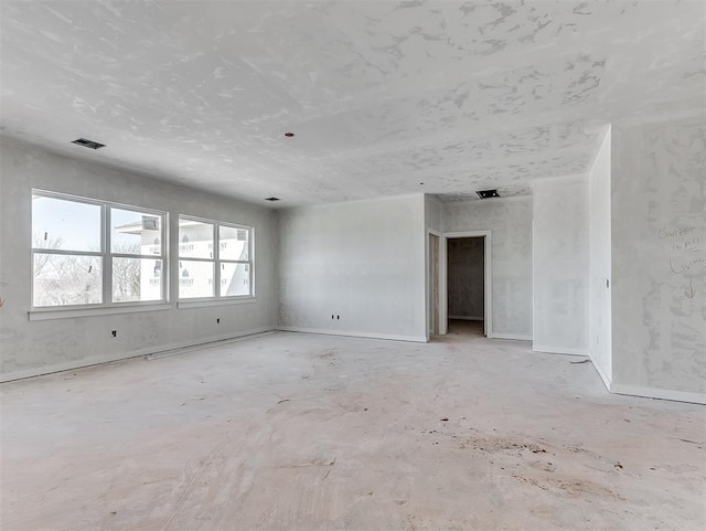 unfurnished room with visible vents