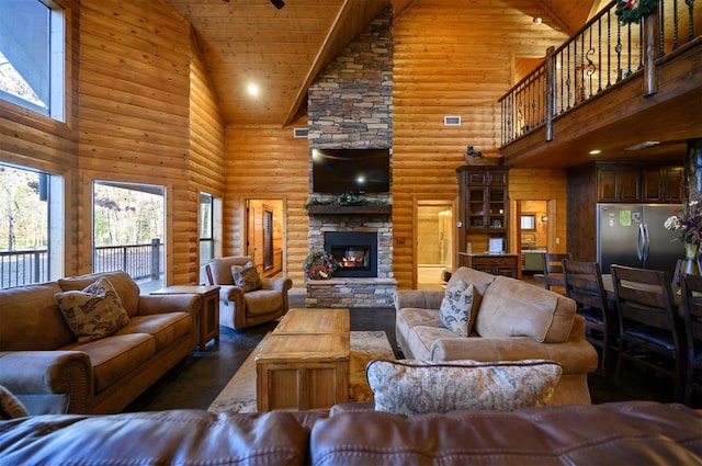 living room with a fireplace, high vaulted ceiling, and log walls