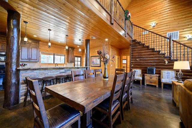 dining room featuring log walls, a towering ceiling, wooden ceiling, and sink