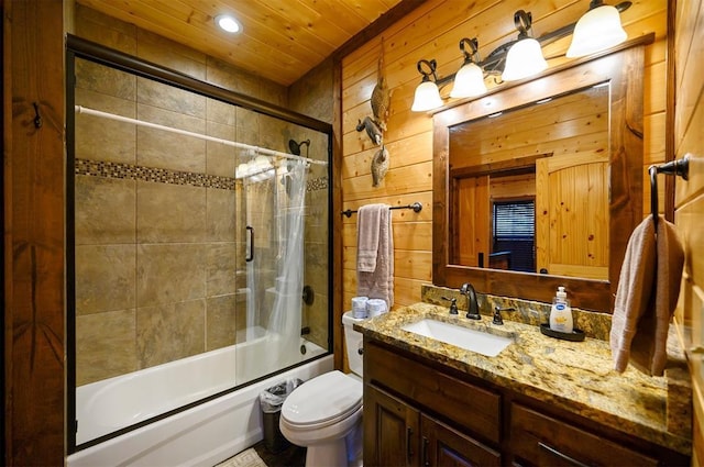 full bathroom featuring tiled shower / bath combo, wood walls, toilet, and vanity