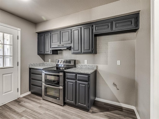 kitchen featuring light hardwood / wood-style flooring and range with two ovens