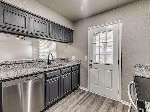 kitchen featuring light stone countertops, appliances with stainless steel finishes, ceiling fan, sink, and light hardwood / wood-style floors