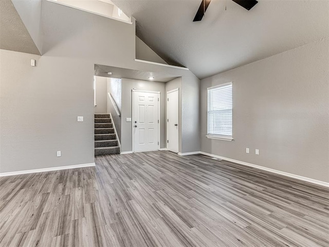 unfurnished living room with high vaulted ceiling, light hardwood / wood-style flooring, and ceiling fan