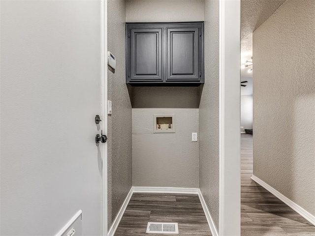 laundry area with hookup for a washing machine, dark hardwood / wood-style flooring, and cabinets