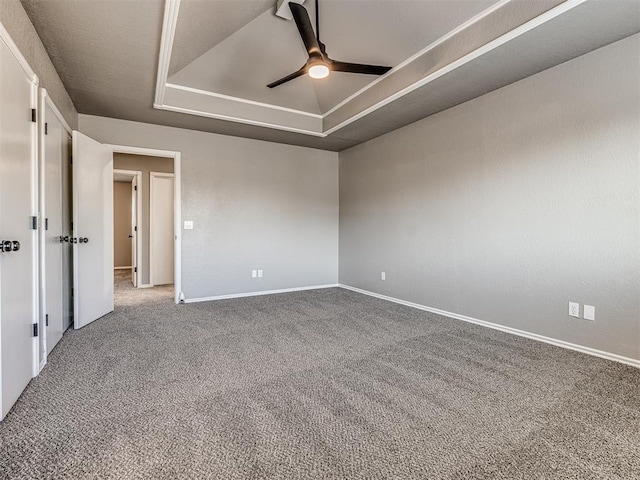 unfurnished room with carpet flooring, ceiling fan, and a raised ceiling