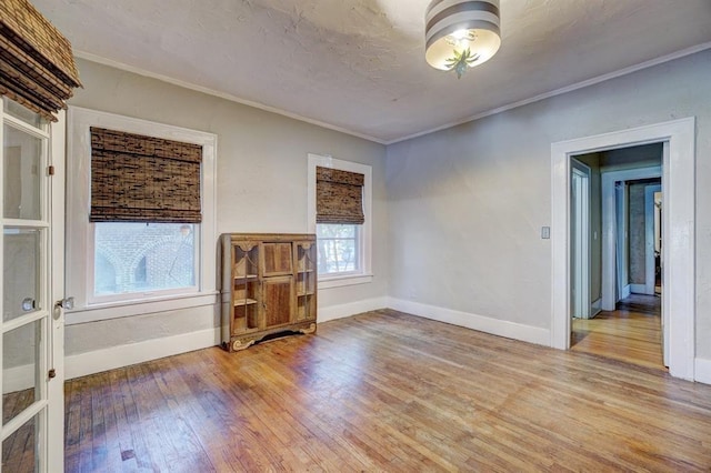 spare room featuring light hardwood / wood-style floors and crown molding