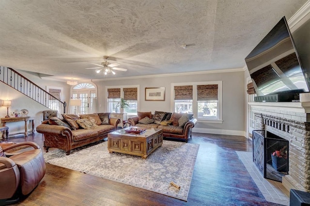 living room featuring crown molding, ceiling fan, dark hardwood / wood-style flooring, and a fireplace