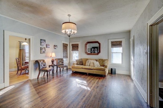 living room with plenty of natural light, dark hardwood / wood-style flooring, and an inviting chandelier