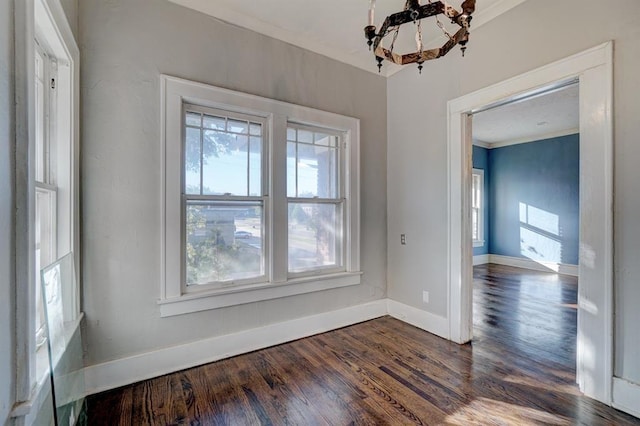 unfurnished dining area featuring an inviting chandelier, dark wood-type flooring, and crown molding