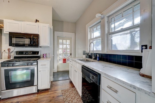 kitchen featuring light stone counters, sink, black appliances, wood-type flooring, and white cabinets