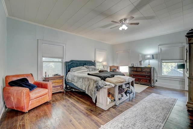 bedroom with ceiling fan, crown molding, and dark wood-type flooring